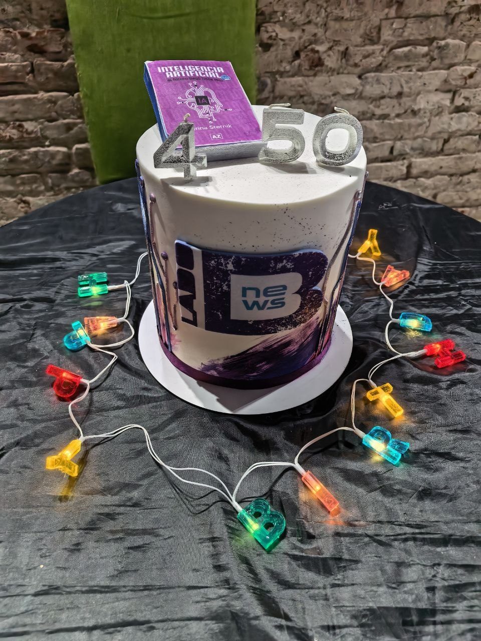 La torta con el logo de LadoBNews, las velas de 4 y 50 y el libro